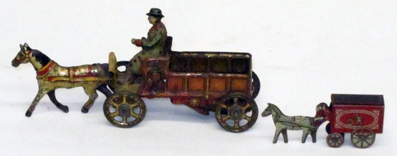 (2) HORSE DRAWN TOYS: (1) Horse drawn penny toy: slotted for animal, but not all of them had one; (1) Cracker Jack delivery; minor rusting and metal discoloration on penny toy; L-4 1/2", F-G