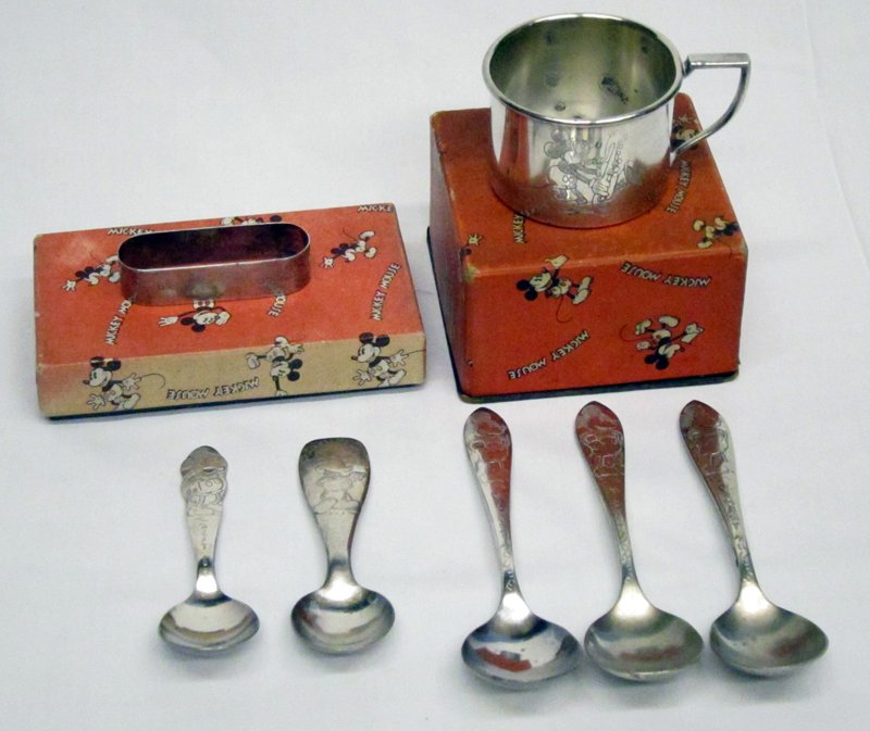 MICKEY MOUSE SILVERPLATE: 1930's; (1) cup in original box, some interior blemishes; (1) napkin ring in partial original box; (2) baby spoons, relief decorated; (3) spoons; longest spoon 5 1/2", G-VG