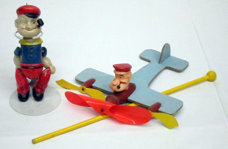 CELLULOID POPEYE FIGURES (2): (1) Popeye the Pilot: in cardboard plane with celluloid props, American 1930's; celluloid is original; cardboard plane has been rebuilt around original (3) pieces; (1) jointed Popeye; plane L-7 1/2", 