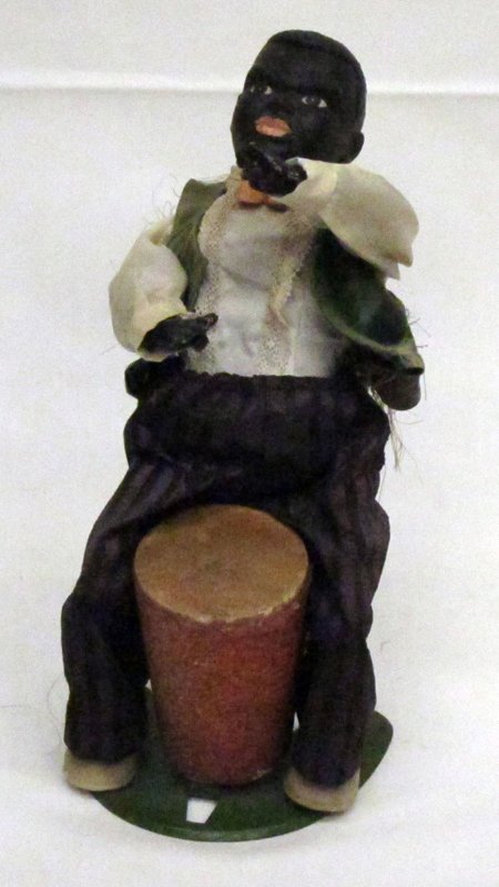 BLACK AMERICANA NATIVE DRUMMER: Vinyl, cloth dressed over tin body; mechanical; needs coaxing to work; vest tattered in the back; H-9", G