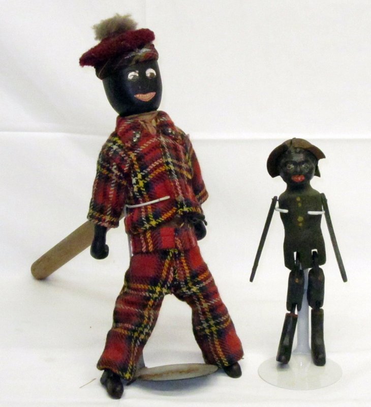 BLACK AMERICANA FOLK JIGGERS (2): Painted wood, jointed; (1) large doll has red cloth clothing; some soil and fading; rod screws into back; body has tape; (1) small doll has chips of wood around hat missing; overall minor paint loss a