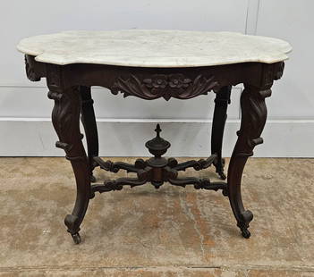 VICTORIAN CENTER TABLE: Walnut with white marble turtle top; foliate and scroll carving; normal wear; H-29 1/2", L-40", G