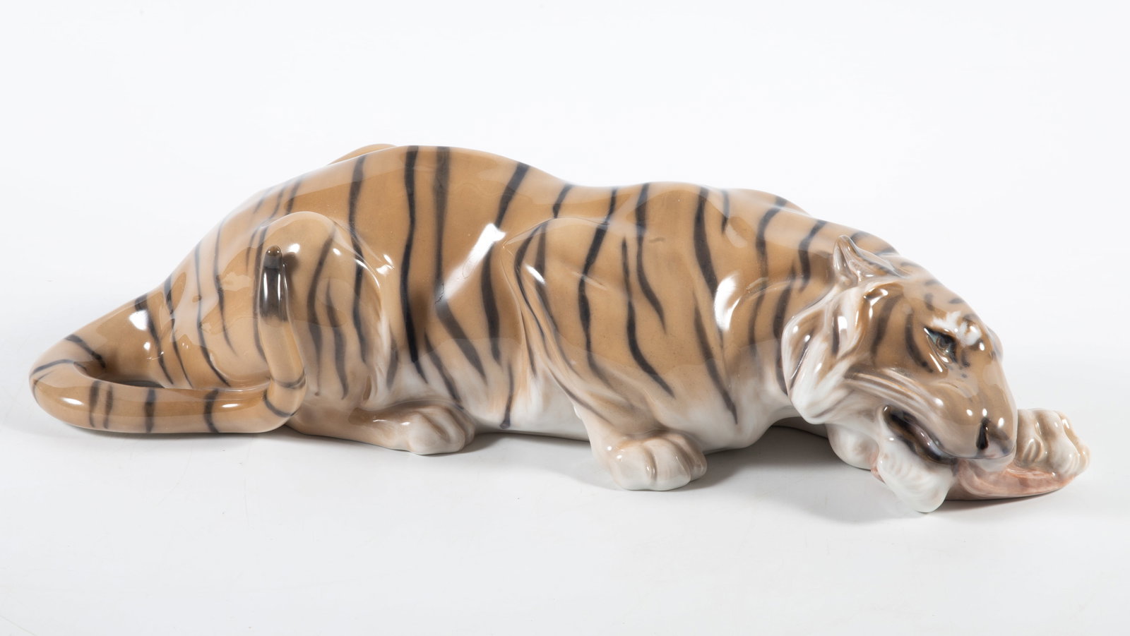 ROYAL COPENHAGEN TIGER: Painted porcelain; tiger gnawing on bone, #2065; normal wear; H-4", L-14", VG-EX