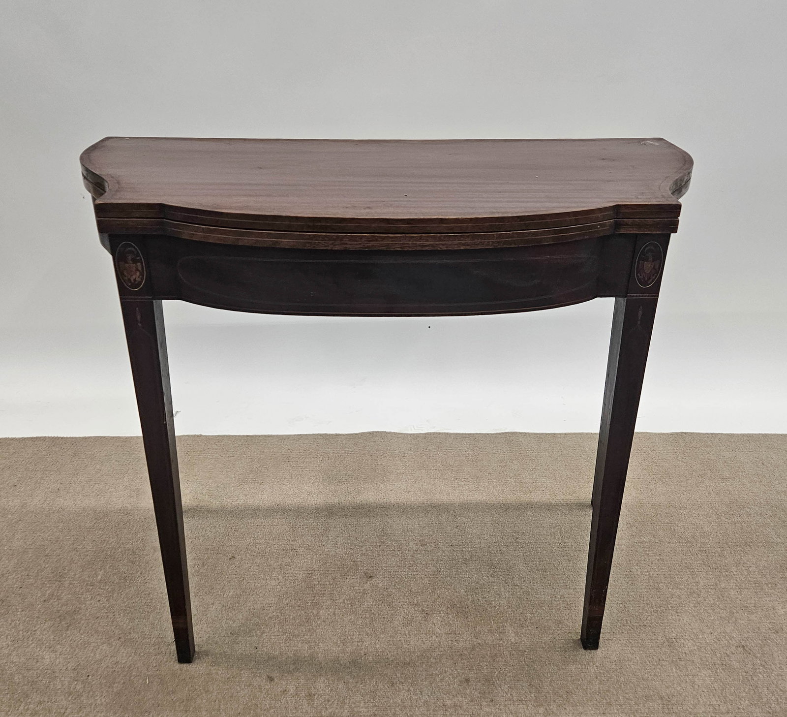 HEPPLEWHITE CARD TABLE: Mahogany swell front; eagle oval and line inlay; normal wear; H-29", L-36", G