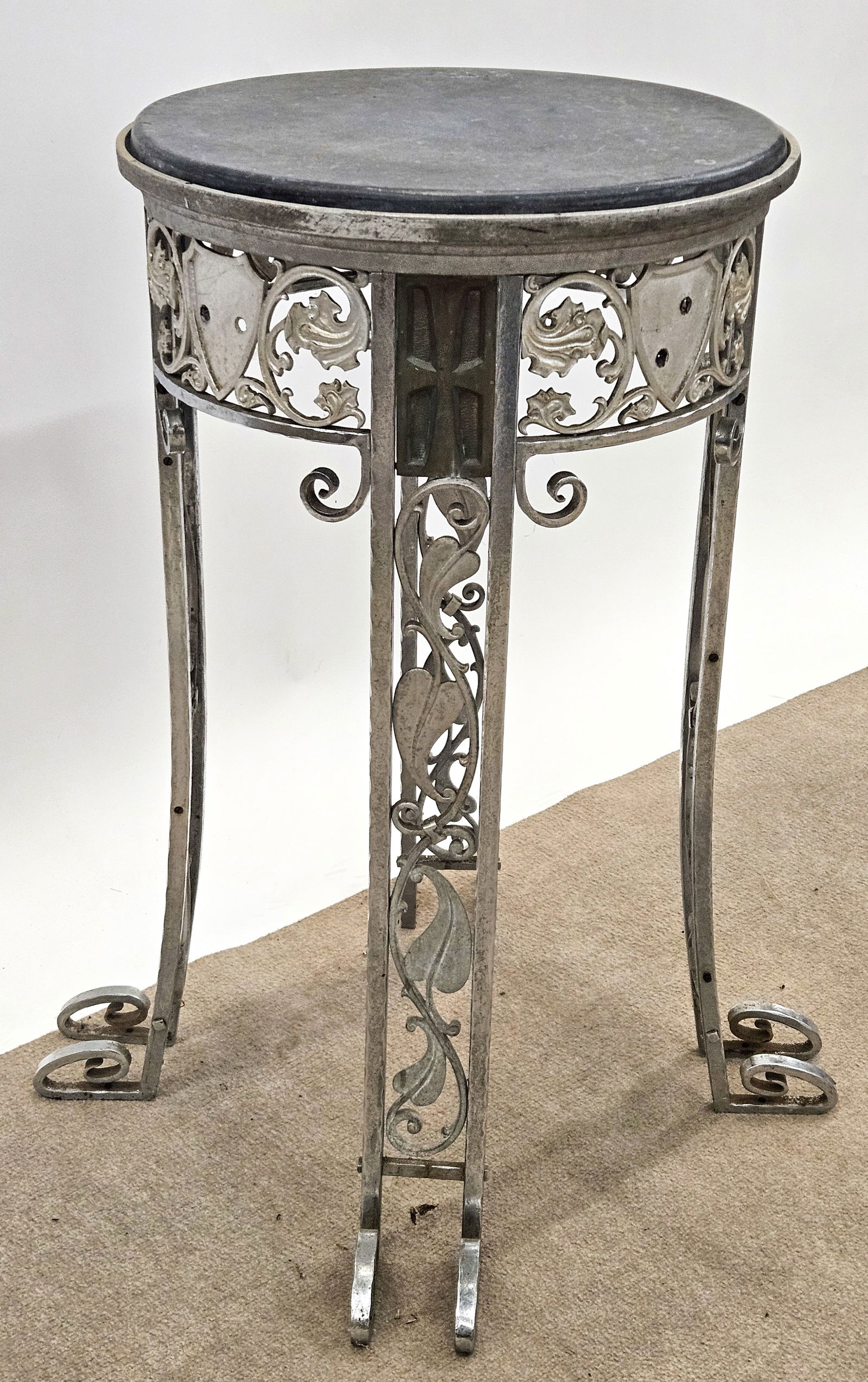 ARTS & CRAFTS STEEL TABOURET: Scrolling oak leaf design; inset slate top; shield inserts missing; H-34", Dia.-19", F-G