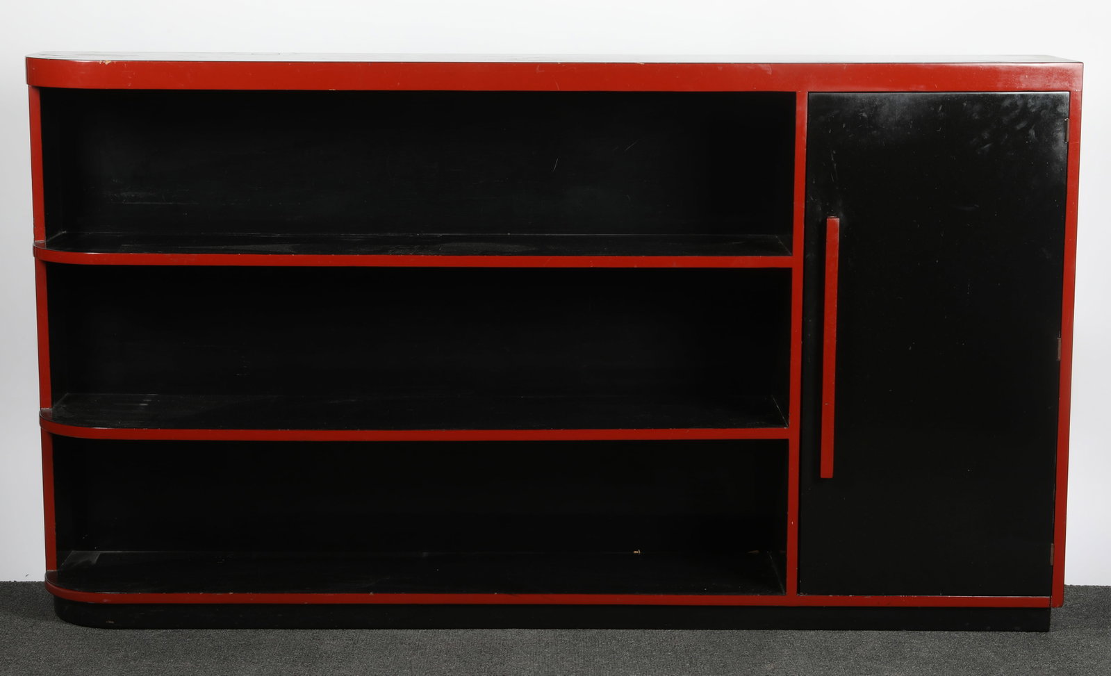 ART DECO STYLE BOOKCASE: Black lacquered wood bookcase with red accents; curved on left end; H-40"xW-72"; normal wear; minor chips, G-G+
