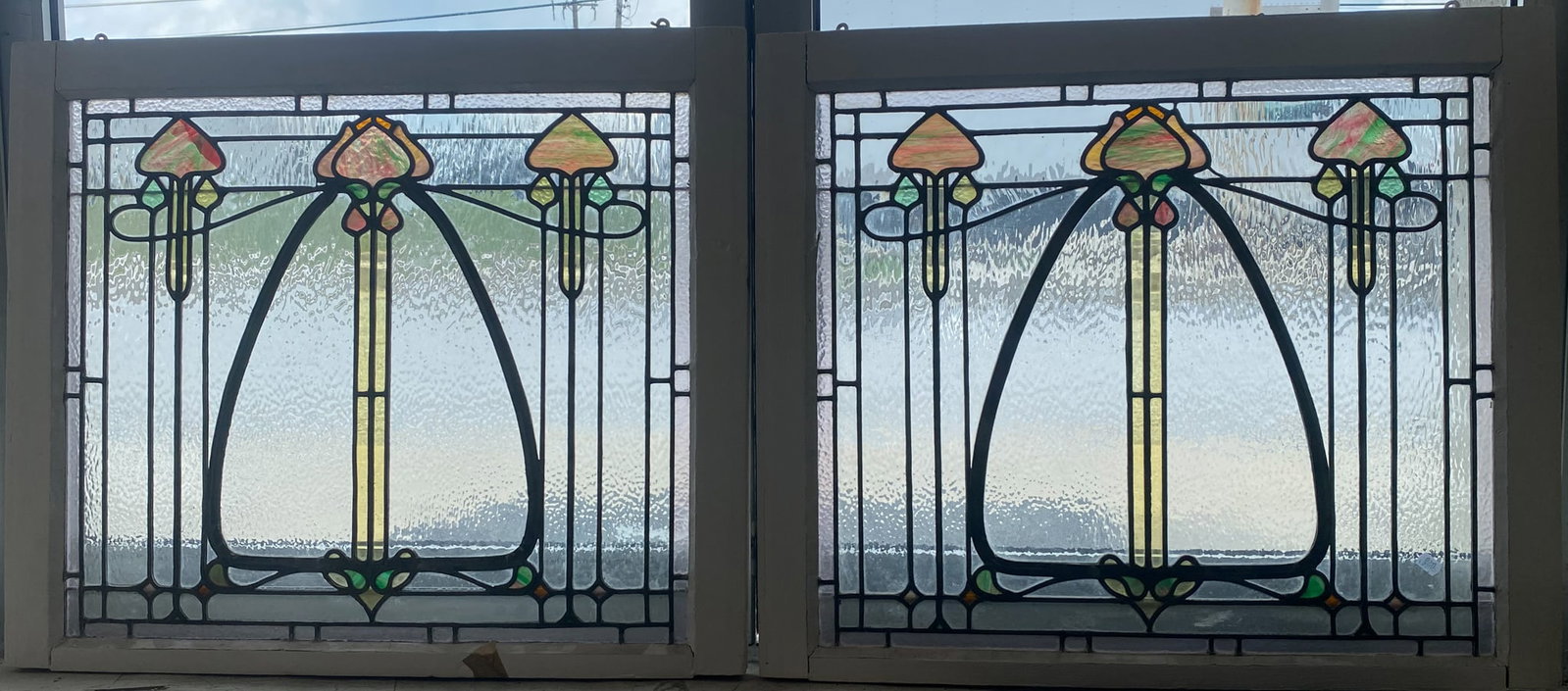 (2) LEADED AND STAINED GLASS PANELS: Pair of art nouveau whiplash designed with rippled glass; wood frame; 29"x34"; (1) small crack; normal wear, G
