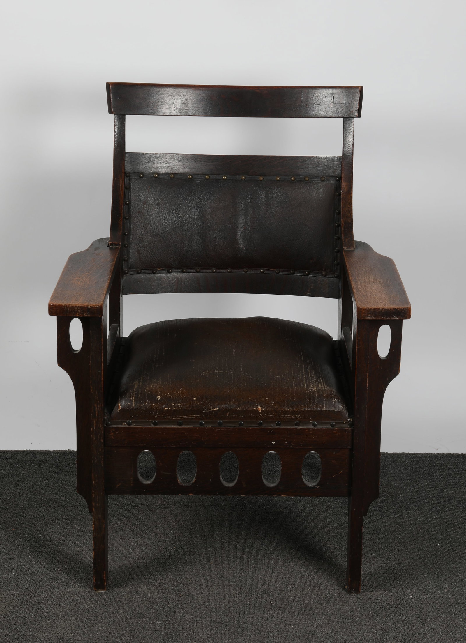 ARTS AND CRAFTS ARMCHAIR: Oak - unusual form; unsigned; original finish; H-38"xW-28"; finish wear, small section of wood chipped off back leg, (2) small cracks in frame, F