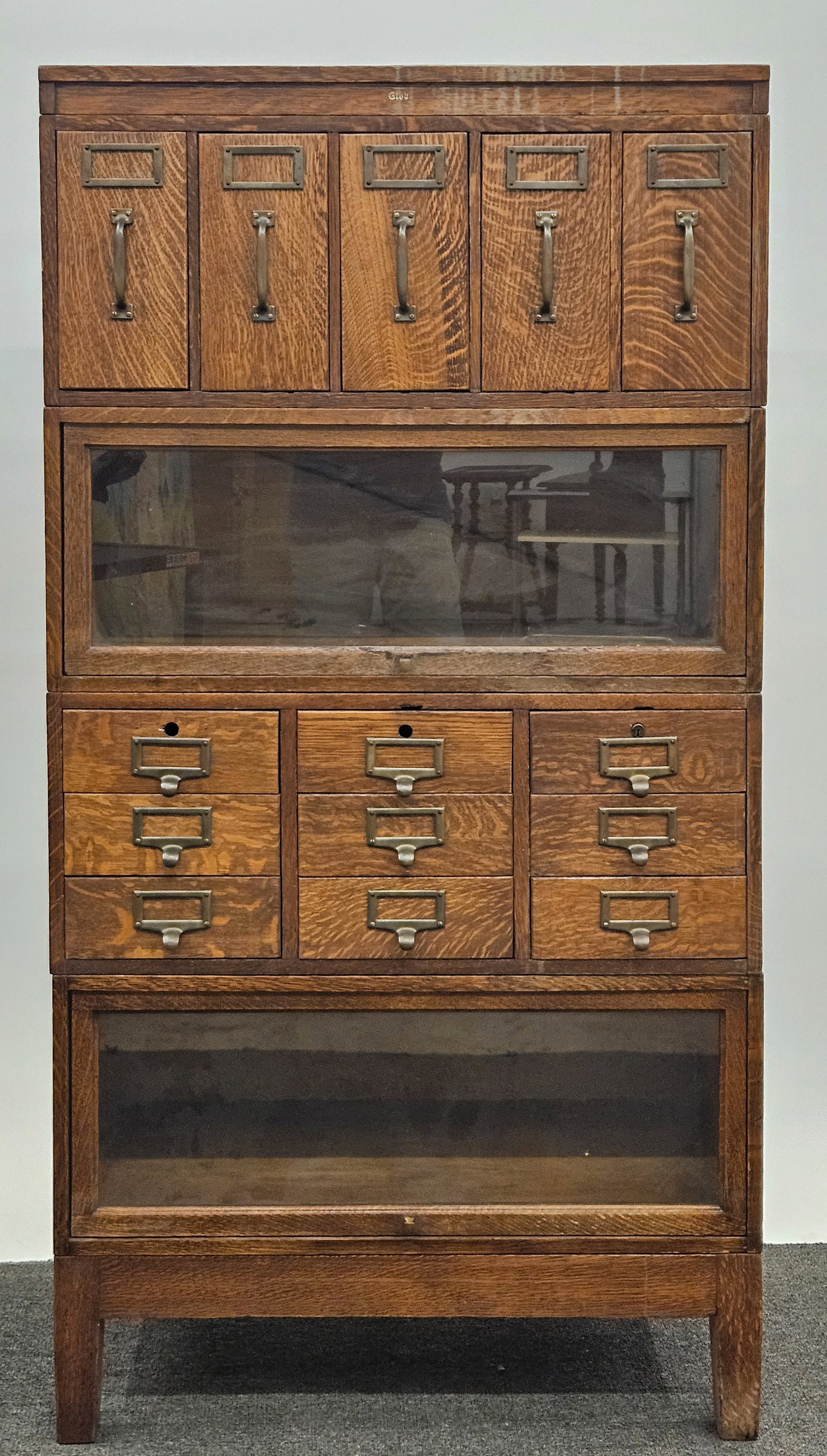 STACKING OFFICE CABINET: Vintage oak; (4) stacking units with separate top and base; drawers have metal interiors; original finish; H-64"xW-33"; wear, missing (2) locks, G