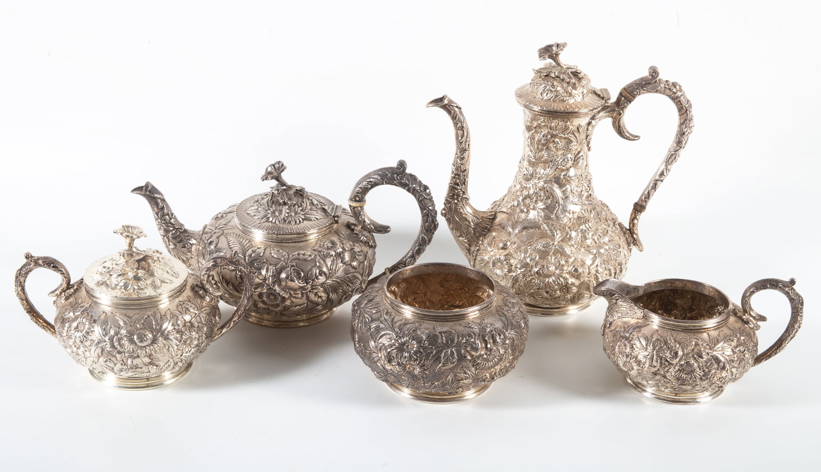 KIRK STERLING REPOUSSE SERVICE: Monogrammed 'L.D.M.'(?) with flower finials - (5) piece coffee and tea service: (1) 9 1/2" tall coffee pot, 29.1 T.O., (1) 5 1/2" squat tea pot, 23.6 T.O., (1) 3 1/2" waste bowl, 13.6 T.O., (1) 4