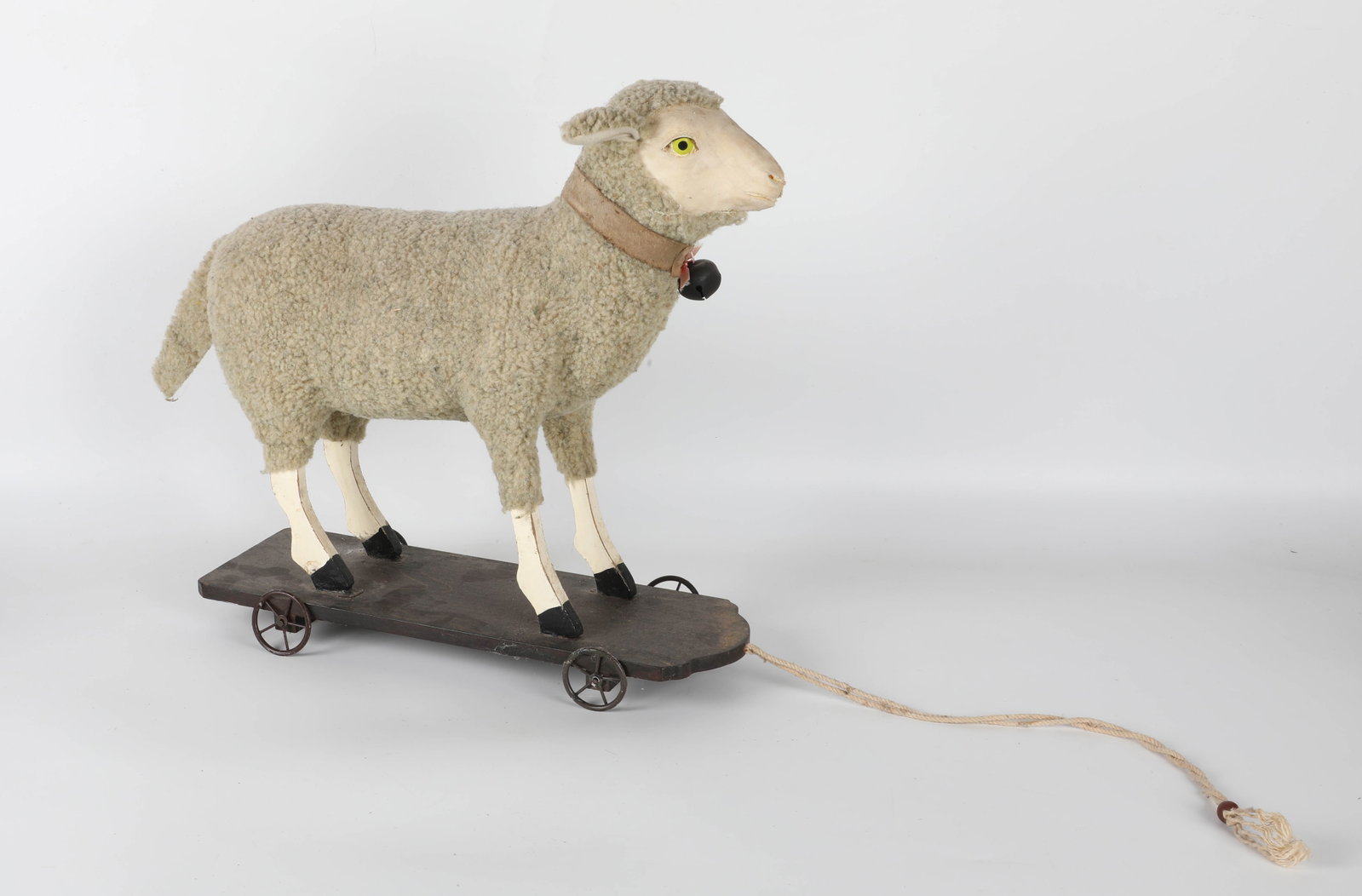 SHEEP PLATFORM TOY: Hide, wool, painted wood base on wheels; painted eyes; unsure of age; 14"x14"; normal wear, VG