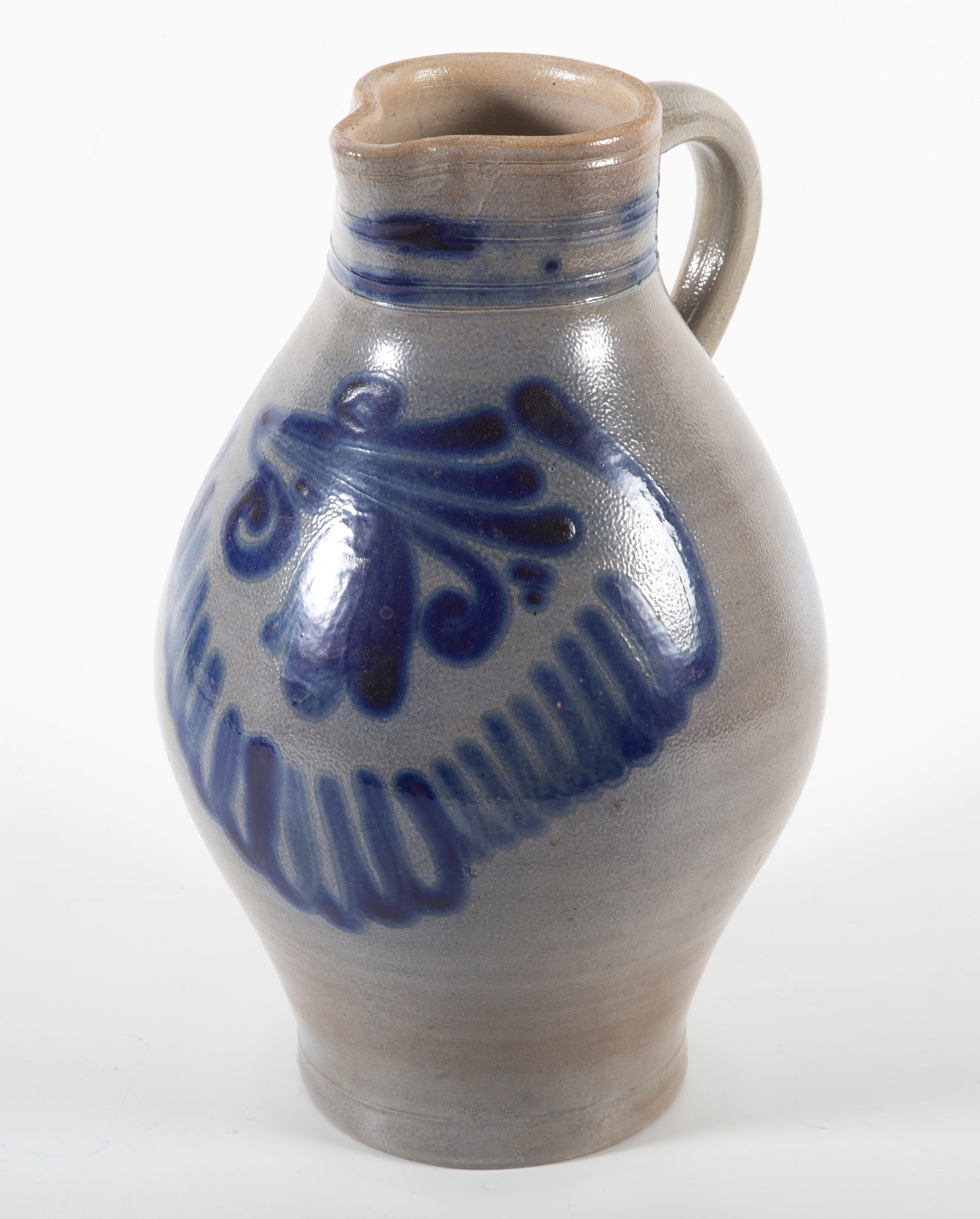 STONEWARE PITCHER: Blue decorated with flower and swag; H-12"xL-3"; normal wear, G-VG