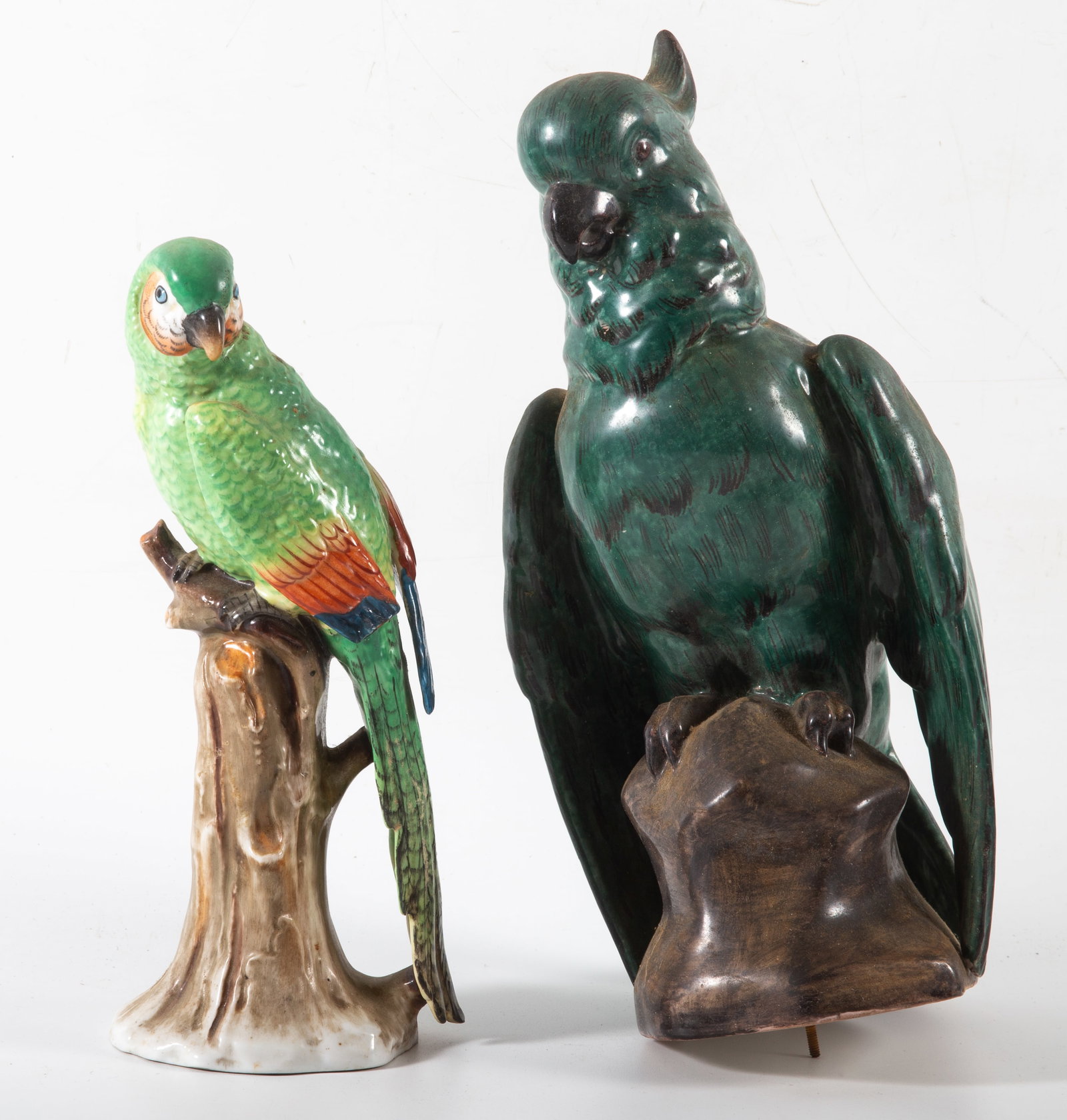 (2) CERAMIC PARROTS: Painted ceramic - (1) green parrot missing a metal base; (1) multi-color parrot - marked Germany, but has anchor mark; H 9 1/2"-11"; normal wear, G
