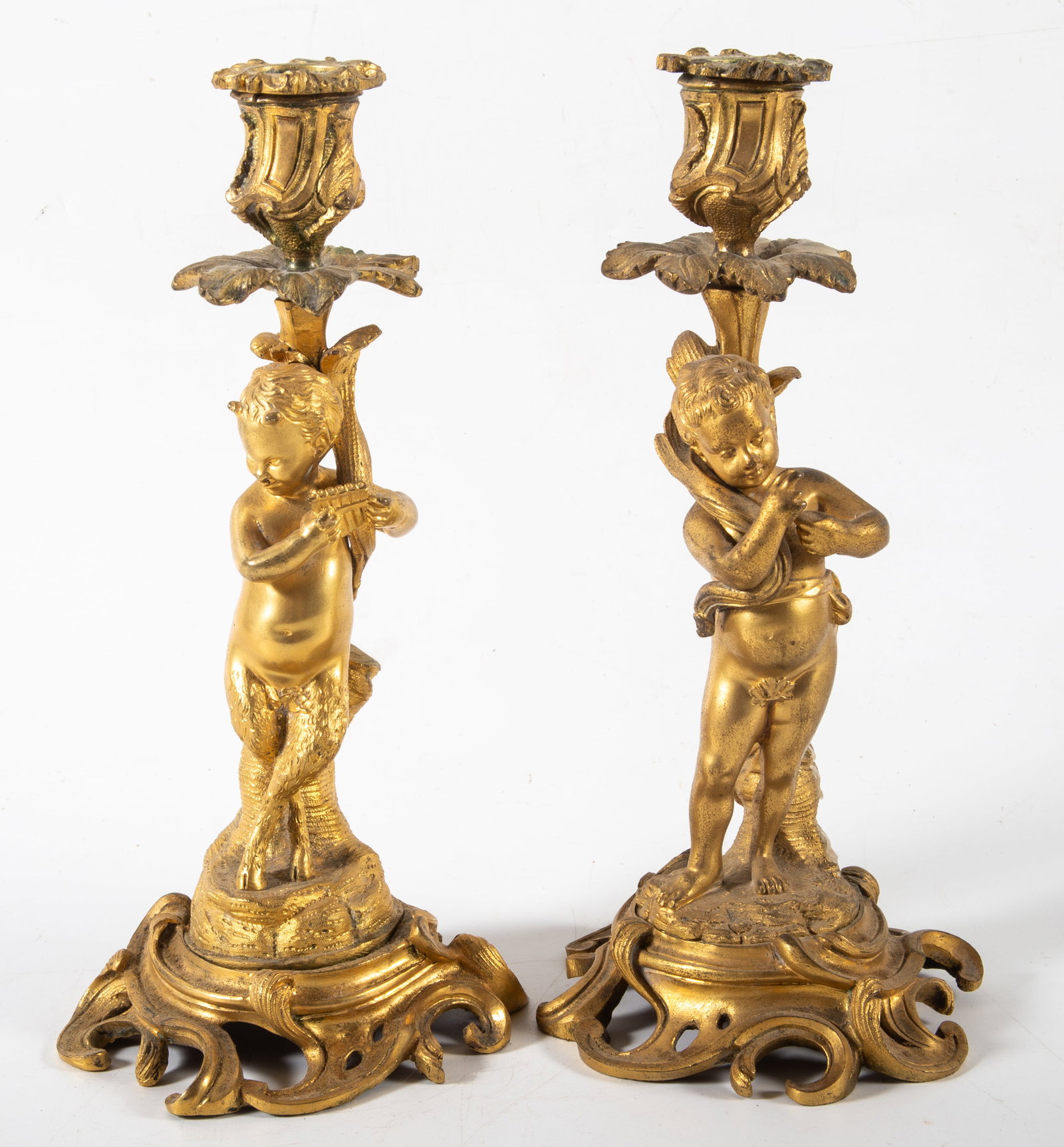 BRONZE CHERUB CANDLESTICKS: Pair of gilt bronze cherub and Pan short candlesticks; normal wear, H-9 1/2", G