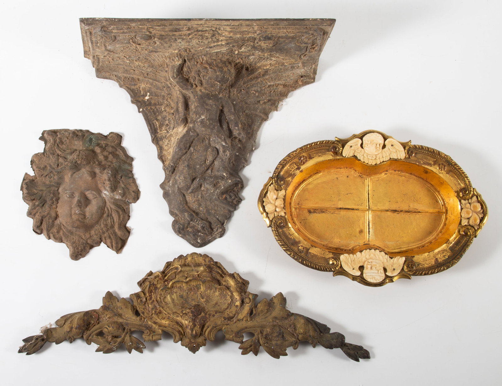 (4) BRONZE AND METAL ORNAMENTS: (1) Gilt bronze swag with shell, L-17"; (1) cast metal cherub sconce, H-10"; (1) gilt bronze dresser tray with applied cherubs- Caldwell, N.Y., L-11"; (1) cast brass face mask, H-7"; P-F