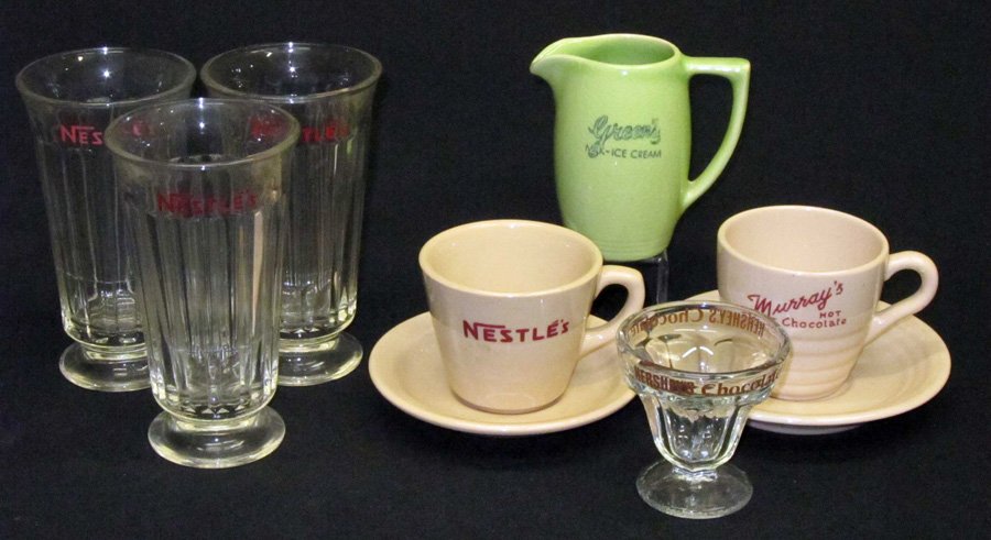 ADVERTISING SODA FOUNTAIN GLASS & CHINA (7) PCS.: (3) Nestles ice cream soda glasses; (1) Hersheys ice cream glass compote; (1) Greens ceramic cream pitcher; (1) Murray's ceramic cup and saucer; (1) Nestles ceramic cup and saucer; tallest 6", G-VG