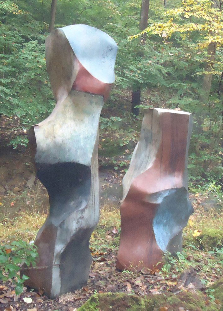 Outdoor Sculpture: Metal free-form pillars; blue wash with red patination, natural oxidation; Artist: Jon Krawczyk "Pudding Stone" H-61"-86"