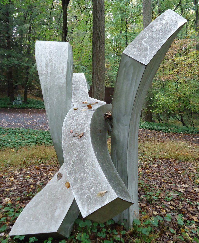 Outdoor Sculpture: Aluminum with brushed / machined surface; dynamic composition consisting of vertical and horizontal elements in a fluid-twisting form; signed with monogram/symbol '98; by Jon Krawczyk, titled "Estrell