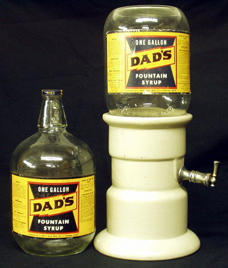 LOT OF DAD'S ROOT BEER ITEMS: (1) Fountain dispenser: pottery base with metal spout; (2) Gallon jugs, (1) with worn label; (2) glasses; (2) mugs; (1) can; (1) barrel bank; Various sizes; EX.