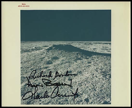 1969 APOLLO 12 CREW SIGNED PHOTO OF MOON: Original NASA issued 8"x10" color press photograph (with red serial ID numbers) that shows a nice close-up view of the Moon surface as seen from Apollo 12. Photo boldly signed in black sharpie by Astr
