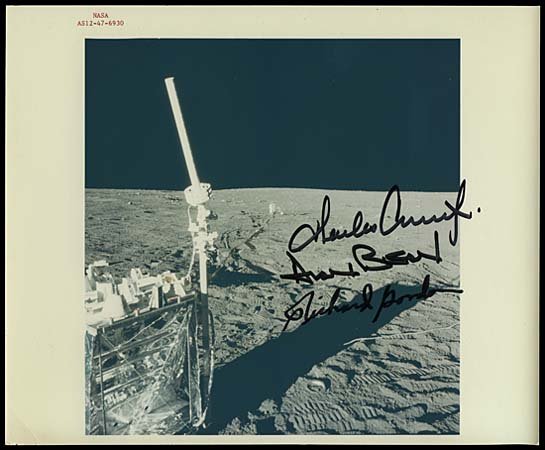 1969 APOLLO 12 CREW SIGNED PHOTO OF MOON: Original NASA issued 8"x10" color press photograph (with red serial ID numbers) that shows a nice close-up view of the Moon surface as seen from Apollo 12 with experiment in foreground. Photo boldly s