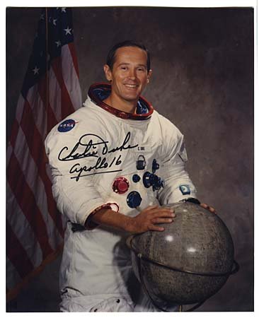 1972 CHARLIE DUKE AUTOGRAPHED GROUP: Contains three autographed 8"x10" color photos and an autographed 8"x10" litho. The litho and one photo are portraits of Duke. Accompanied by a 5½"x3" booklet entitled, 'Walk on the Moon, Walk with t