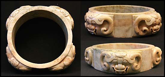 LARGE JADE CIRCLE, SHANG DYNASTY STYLE: Very large and rare white/green jade circle with four lion's masks highly detailed with open mouths and equidistant from each other on exterior of ring. Made in the style of the Shang Dynasty. Locking
