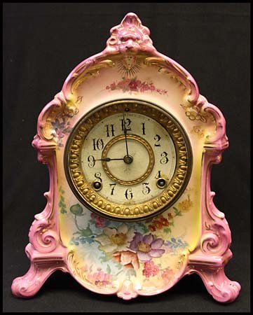 c.1882 ANSONIA MANTLE CLOCK ROYAL BONN CHINA: Lovely Ansonia mantle clock of Royal Bonn China, with beautiful pink and gold trim and multicolor floral design. Marked La Ramblu on back. Includes pendulum. 11½ tall, 7 lbs. Very fine.