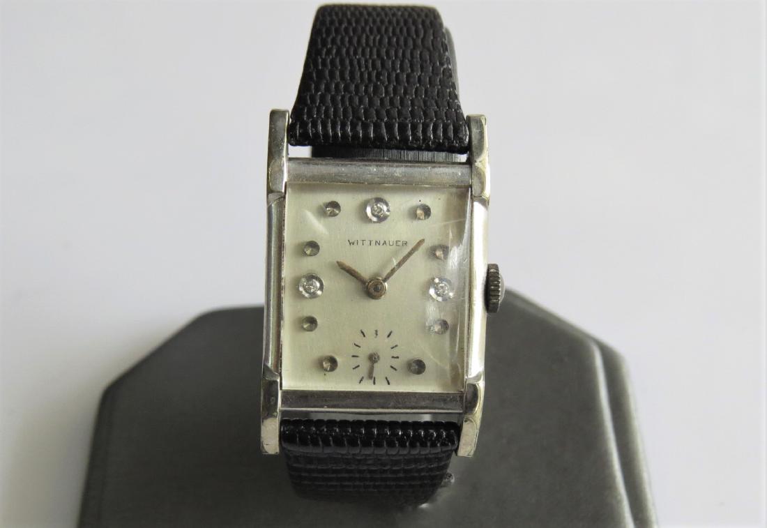 Vintage Wittnauer Gold and Diamond Watch: Vintage Wittnauer 10K white gold filled wrist watch with diamond hour markers. 17 jewel. Black genuine lizard calf band. Square face. 21 mm case. 14 mm band width with 6 adjustable wrist sizes. 16.0 D