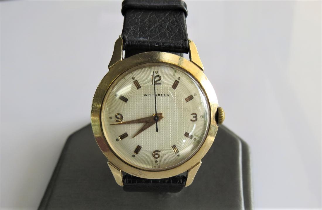 Vintage Wittnauer Watch: Vintage 10K yellow gold filled bezel Wittnauer wrist watch. Black genuine leather band. Stainless steel back. Swiss made. Year unknown. 30mm case. 15mm band width - with 7 adjustable wrist sizes. 20.2