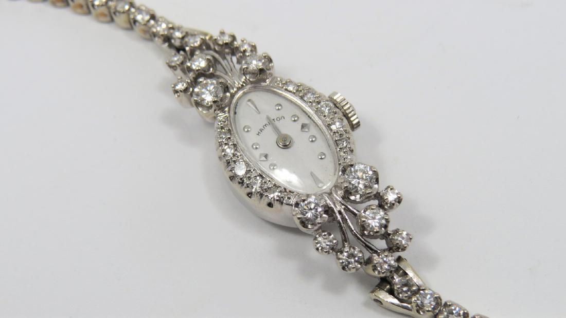 Diamond and Gold Hamilton Watch: Stunning 14K white gold and diamond Hamilton ladies wrist watch. Approximately 2.14 CT TDW. 18.4 grams. 6.5" length. Oval shaped face measures 14mm x 18mm. Vintage. Working intermittently.