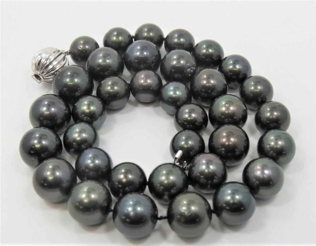 Certified Tahitian Pearl Necklace: Certified cultured Tahitian pearl necklace. 35 Graduated 11-14mm pearls. Necklace measures 18" with a scalloped 14K white gold plunger style bead clasp. Total weight of 92.1 grams.
