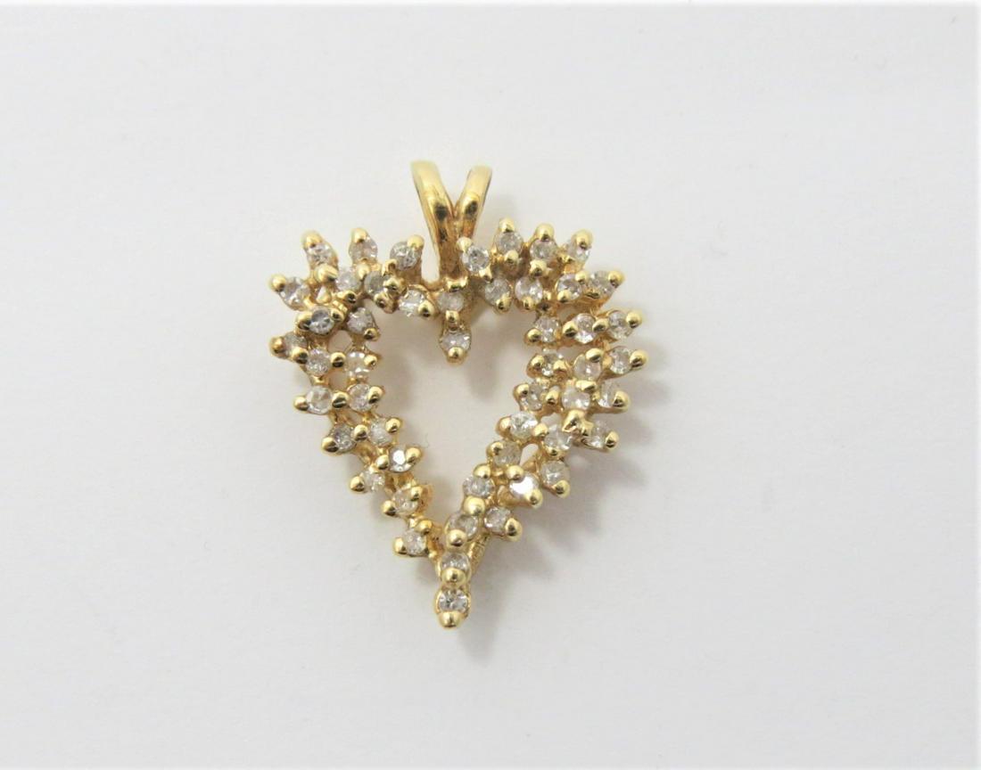 14K Yellow Gold Diamond Heart Pendant: Stamped 14K yellow gold cluster style heart pendant with split fixed bail. Set with approximately 0.25 cts in diamonds. 2.8 grams. 23 mm x 18.3 mm.