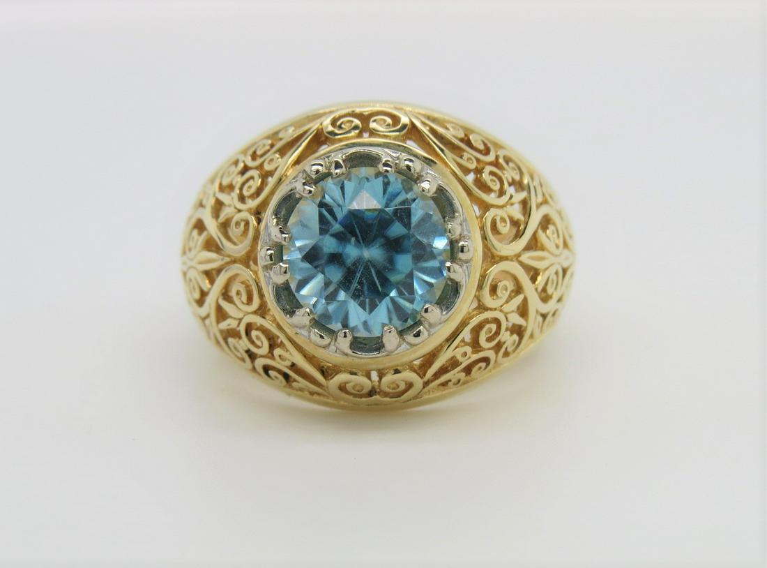 14K Yellow Gold Blue Zircon Ring: Stamped 14K two tone gold ring with an elaborate filigree design, decorative set with a 3.80 ct blue zircon. Yellow gold band with white gold prongs. Ring size 8. Weighs 8.7 grams.