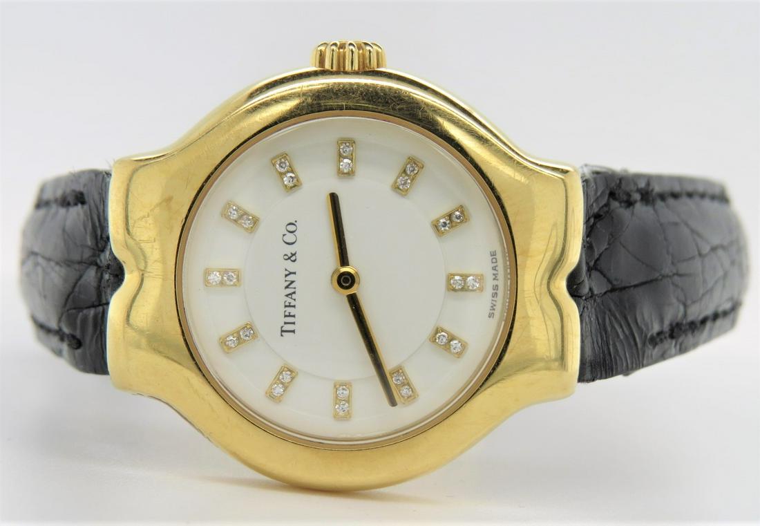 Vintage 18K Yellow Gold Tiffany & Co Watch: Vintage stamped 18K yellow gold Tiffany & Co ladies watch. Swiss made. Diamond hour markers. Tesoro. Serial number 35-119. Model number L0130. 24 mm case, ivory face. Approximately 0.12 cts total diam