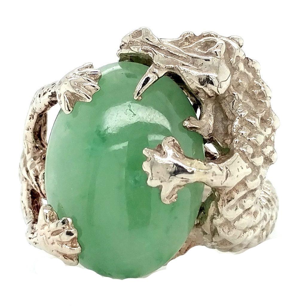 14k White Gold Jadeite Dragon Ring: Stamped 14K white gold Jadeite dragon ring. Detail goes all the way around shank. Ring size 7. Jade measures 15.5 mm x 12.5 mm, oval shaped. Total ring weight of 9.4 grams. This is a brand new item.