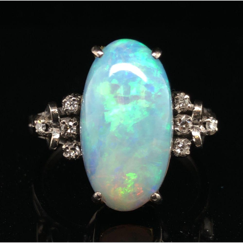 Genuine Opal and Diamond Ring: This is a vintage 18 karat white gold natural genuine opal and natural diamond ring. The approximate 5 carat genuine opal exhibits green and blue fire with lovely pink overtones. The ring