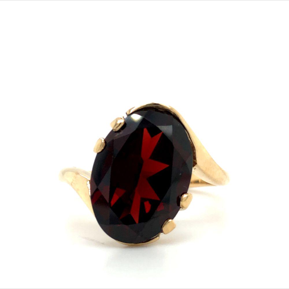 Garnet Ring: Garnet Ring in 10 karat yellow gold. A simply beautiful 6.00 carat oval, faceted garnet in a bypass style ring. The ring is US size 7. This ring can be resized for an additional $75,