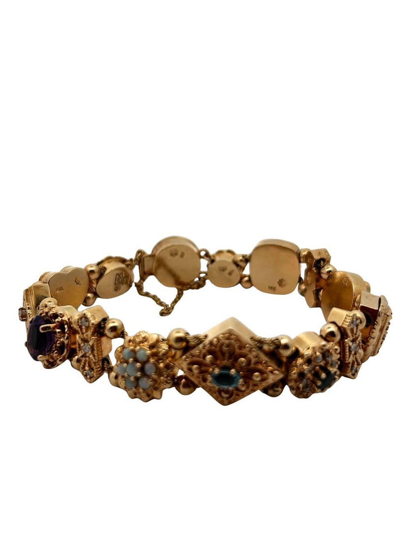 14K Vintage Charm Bracelet: S/45.8-NNSS This captivating 14K yellow gold charm bracelet is a true testament to masterful craftsmanship and vintage style. The bracelet is composed of a series of exquisitely detailed, articulated