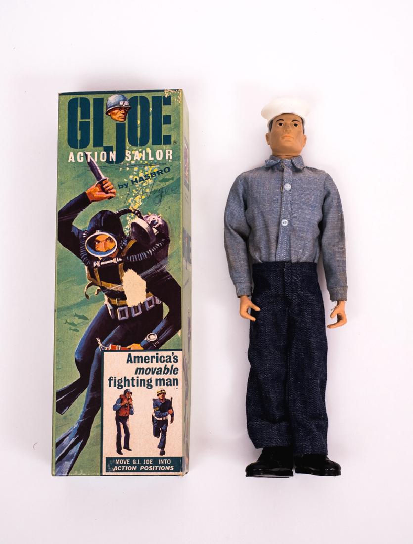 1964 G.I. Joe Action Sailor in OB: DESCRIPTION: 1964 G.I. Joe Action Sailor item # 7600 in original coffin box. CONDITION: Missing dog tag, manual, and pamphlet. Stress crack to both knees. Minor discoloration to face. Box with ink wri