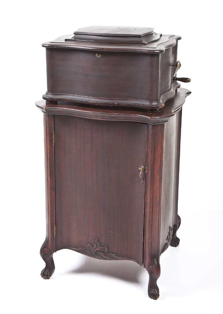 19th C Regina Style 50 Music Player & Cabinet: DESCRIPTION: Regina disc music player with storage cabinet and sixty-two (62) discs. Style 50 with serpentine mahogany case and serpentine mahogany storage cabinet with claw and ball feet. Double comb
