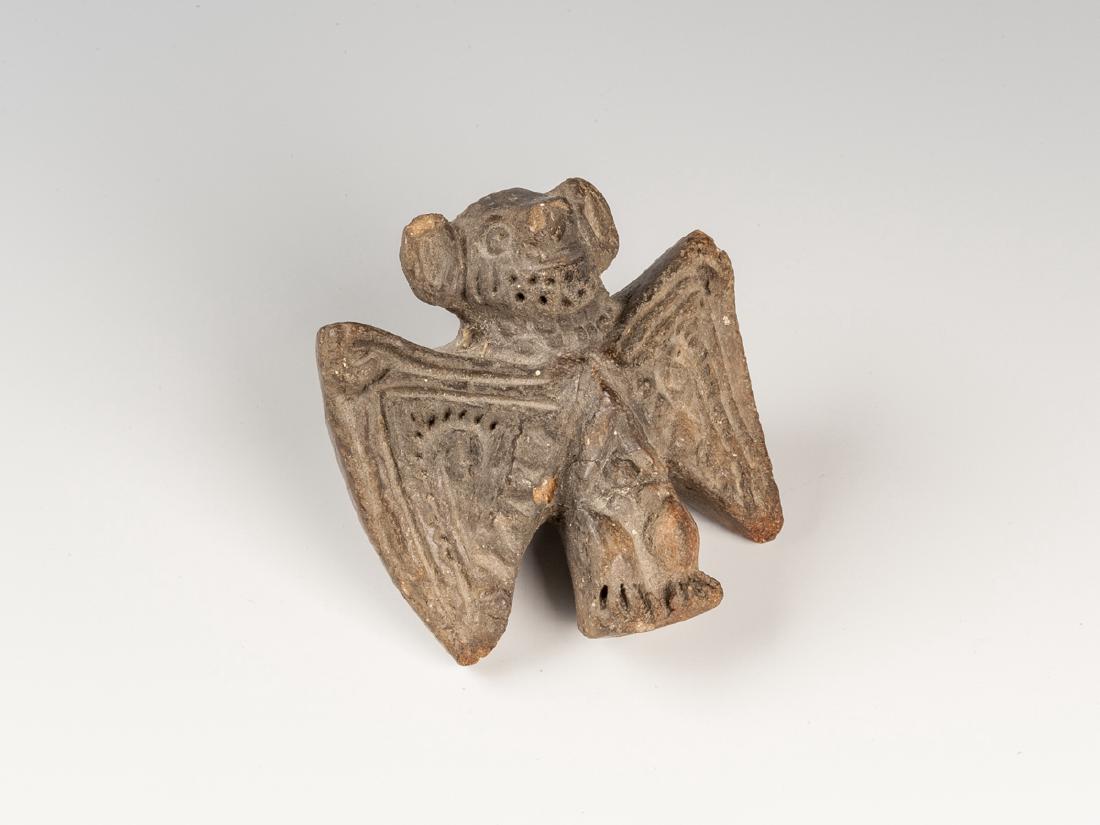 Pre-Columbian Bat Whistle: DESCRIPTION: Pre-Columbian bat form whistle. Outstretched wigs above humanoid lower half with male genitalia. Wings with geometric and scroll decoration. Head with large ears and exposed teeth. Brownw