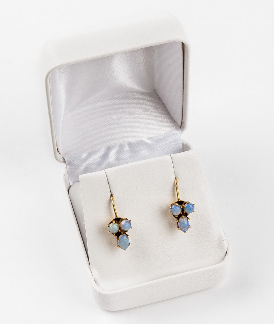 10K Opal Earrings: 10k (stamped) screwback earrings each set with three opals. 5/8". 1.5 dtw (2.3 gr).