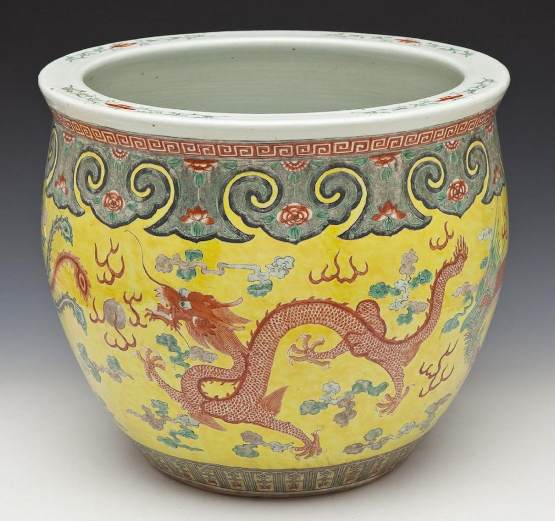 Chinese Famille Jaune Jardiniere: DESCRIPTION: Large Chinese Famille Jaune jardiniere with enameled four dragons and lotus flowers on a yellow field. Early 20th century. MEASUREMENTS: 18" diameter x 16" tall. CONDITION: Superficial sc