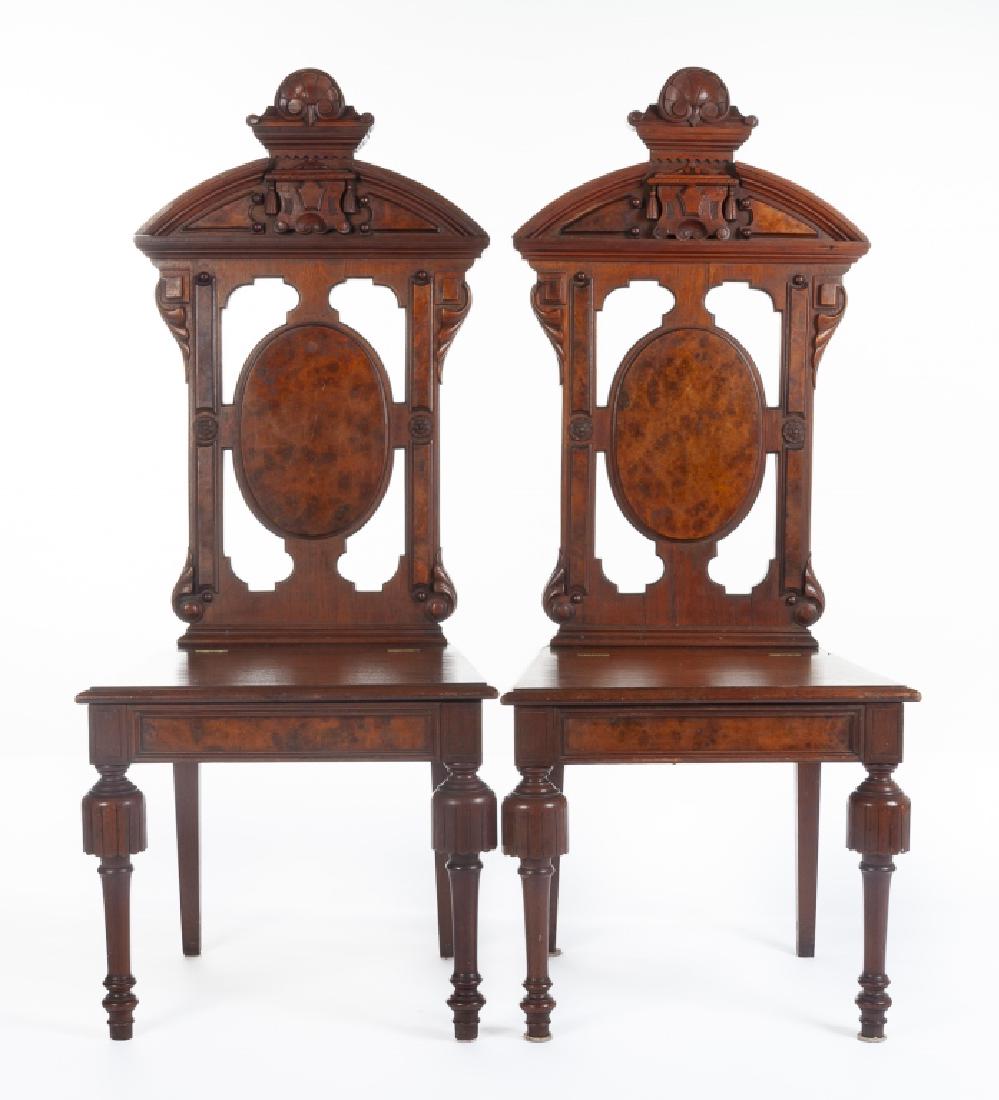 Pair of American Renaissance Revival Hall Chairs: DESCRIPTION: Pair of American walnut period Renaissance Revival hall chairs. Circa 1860. The form consisting of matching turned legs and burl splats with hinged lift top seats. The crests with carved 