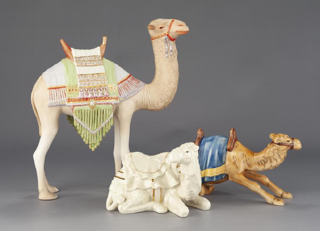Three Porcelain Camels incl Cybis: DESCRIPTION: Three porcelain camels. Includes: 1) Cybis camel, 1982. 9" wide x 10" high. 2) Goebel kneeling camel 46 858. 7" long x 4-1/2" high. 3) Belleek camel from Living Nativity Collection. 5-1/2