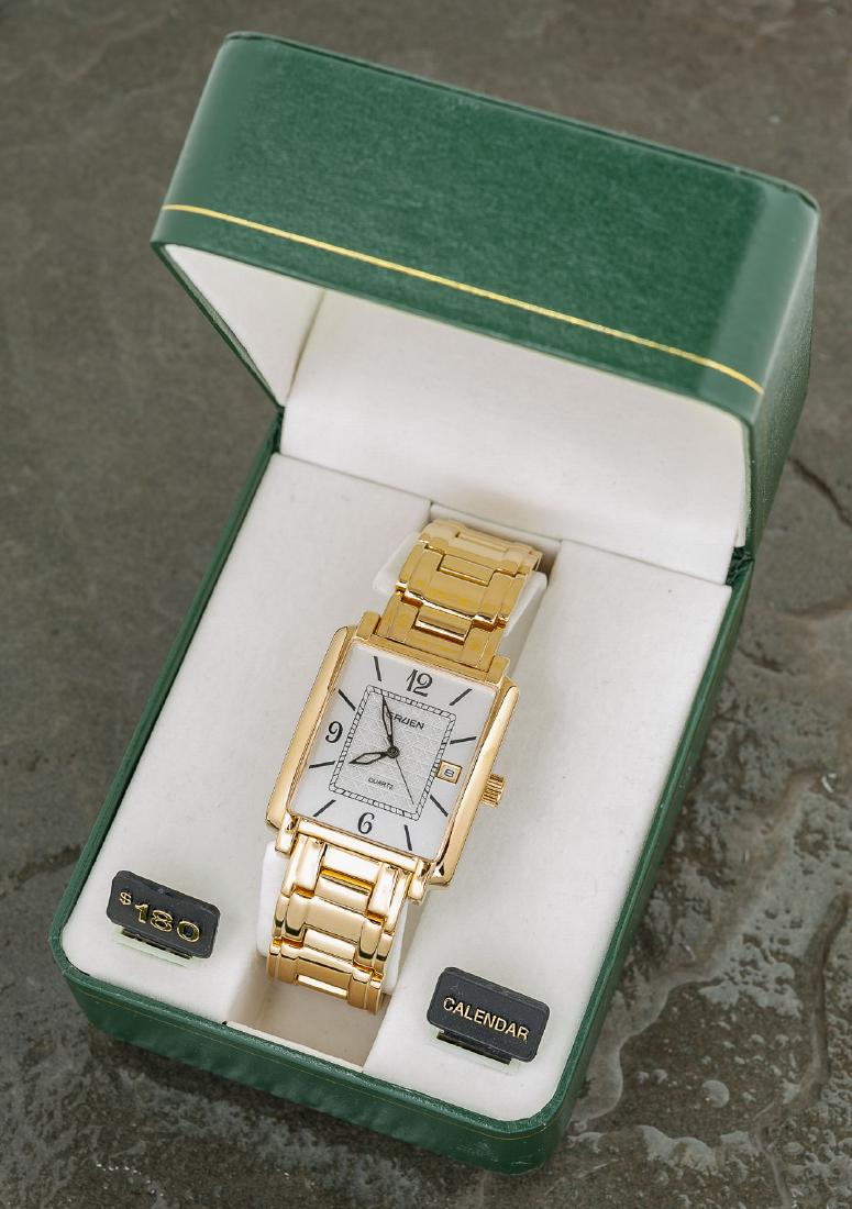 Gruen Calendar Wristwatch: DESCRIPTION: Gruen quartz calendar wristwatch. MEASUREMENTS: 1-1/2" lug to lug. CONDITION: New in box.