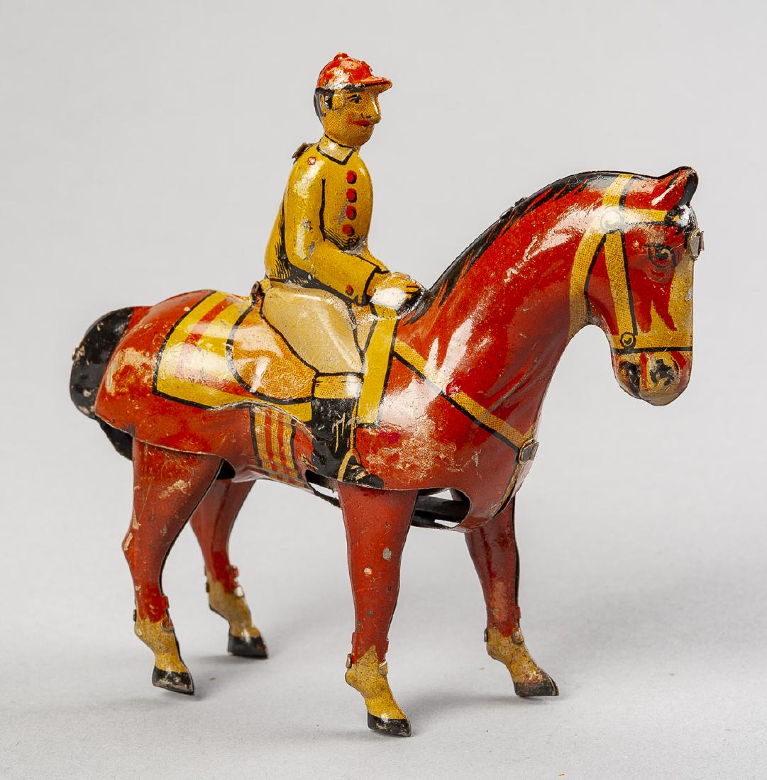 German Jockey on Horse Tin Litho Wind Up Toy: DESCRIPTION: Antique jockey on horse tin litho wind up toy. Made in Germany. Circa early 20th century. MEASUREMENTS: 5". CONDITION: Wear and losses to litho. Missing key.