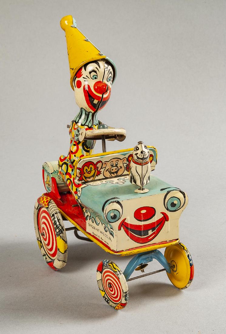 Unique Art Artie the Clown Wind Up Toy: DESCRIPTION: Unique Art Artie the Clown tin litho wind up toy. MEASUREMENTS: 7" long x 8" high. CONDITION: Light scratching. Works