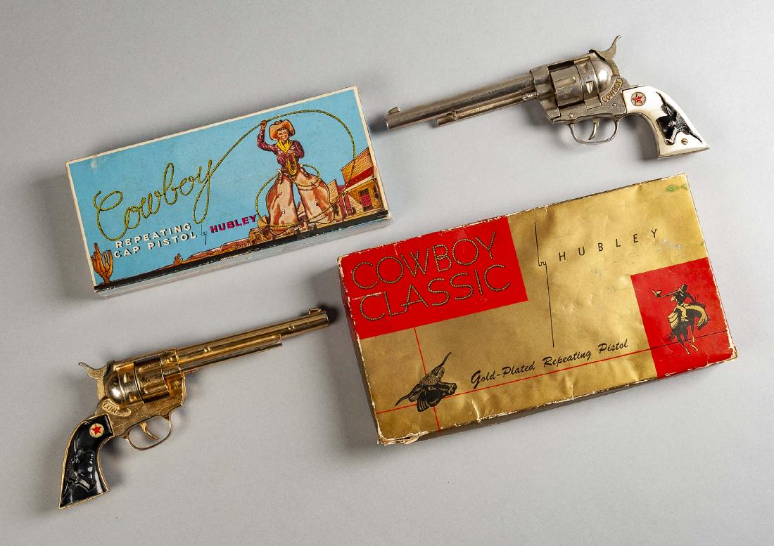 2 Hubley Cap Guns with OBs Incl Cowboy Classic: DESCRIPTION: Two Hubley cap guns. Includes: 1) Cowboy with white grips and original box. Gun 11/1/2" long. Minor surface wear to gun. Box missing one end flap. 2) Hubley Cowboy Classic No. 276 gold-pl